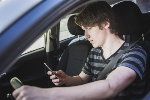 young man texting behind the wheel
