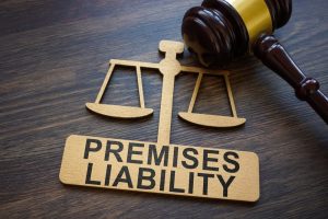 Gavel and laser-cut figure that says premises liability on a wooden desk.