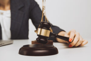 woman judge holding a gavel while reviewing documents at her desk