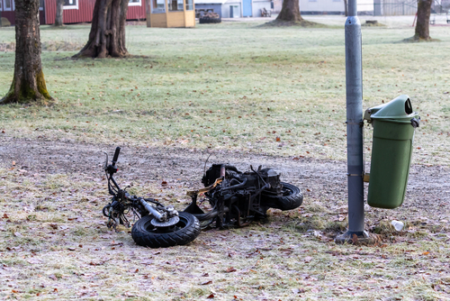 Burned remains of an electric scooter on the ground after a fire, representing an E-Bike and E-Scooter Battery Fire Injury incident.