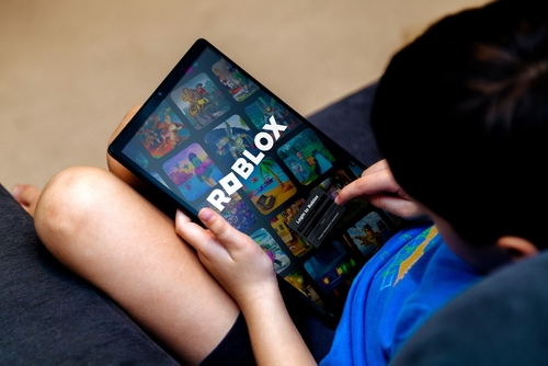 Child using a tablet with the Roblox app open, representing issues central to a Roblox Addiction Lawsuit.