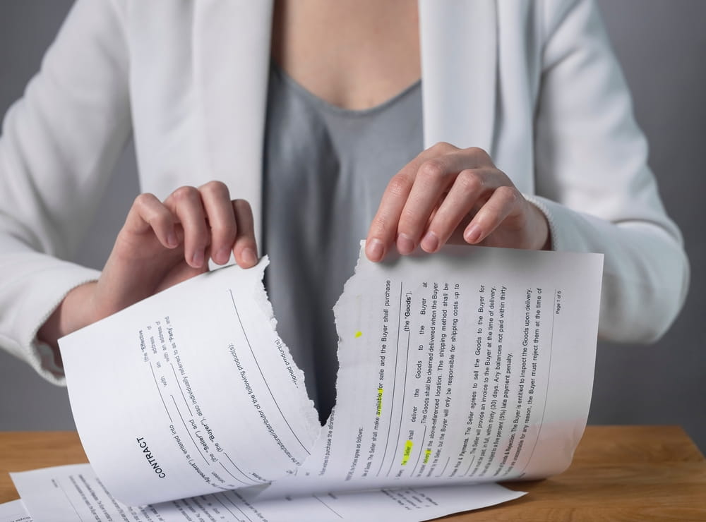 Person tearing employment contract symbolizing wrongful termination dispute in New York