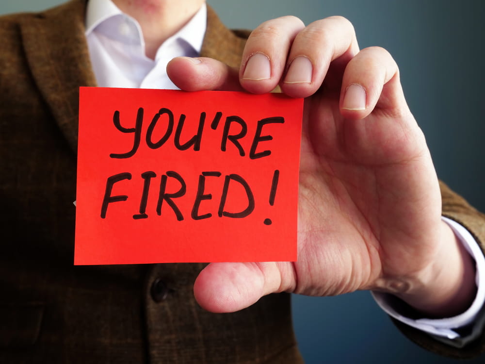Employer holding &ldquo;You&rsquo;re fired&rdquo; sign illustrating sudden job termination in New York